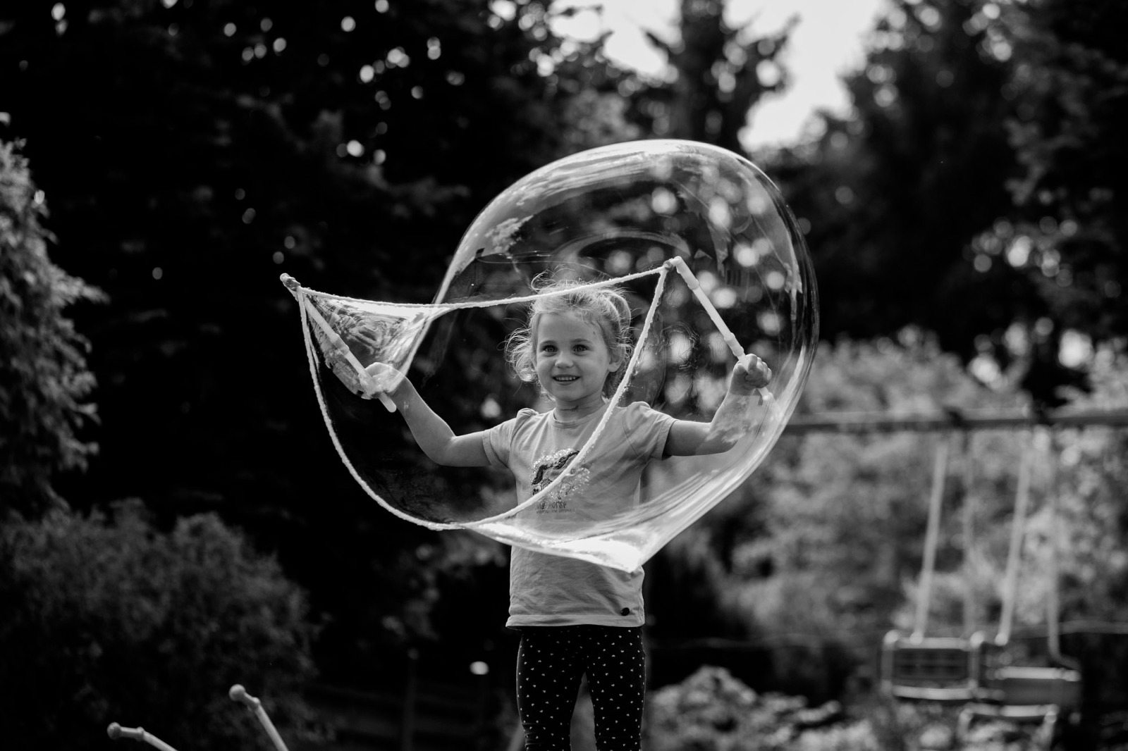 Mädchen spielt mit Riesenseifenblasen