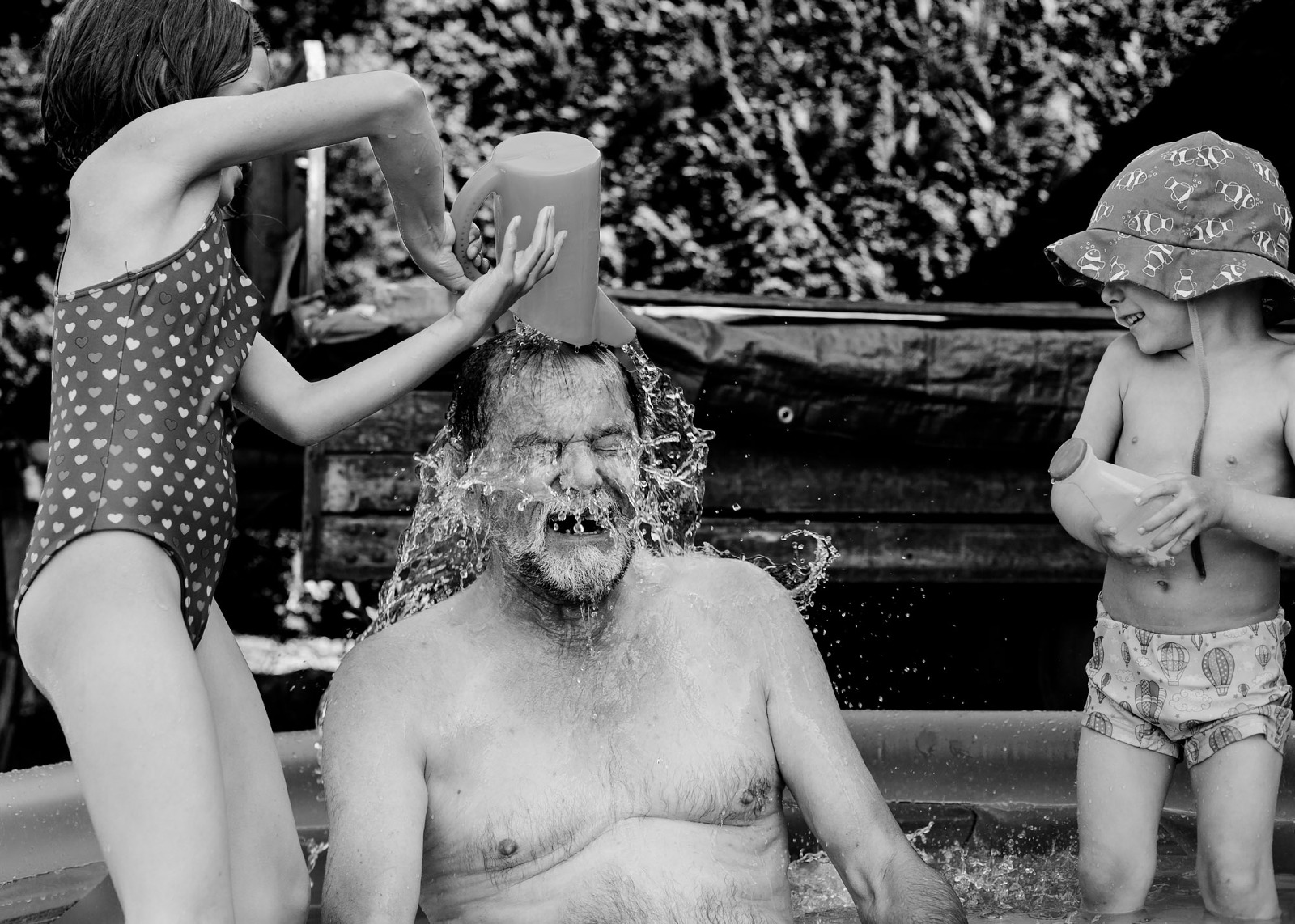 Opa wird mit einem Eimer Wasser getauft